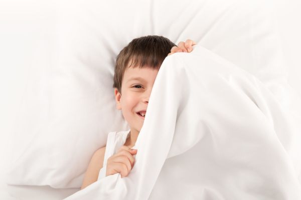 enfant souriant dans un lit