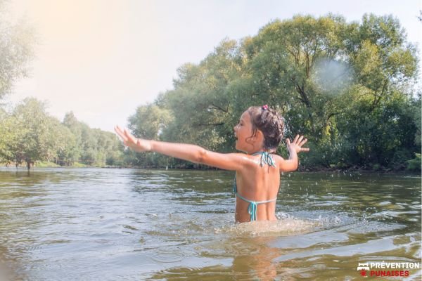 enfant se baigne dans une rivière trouble